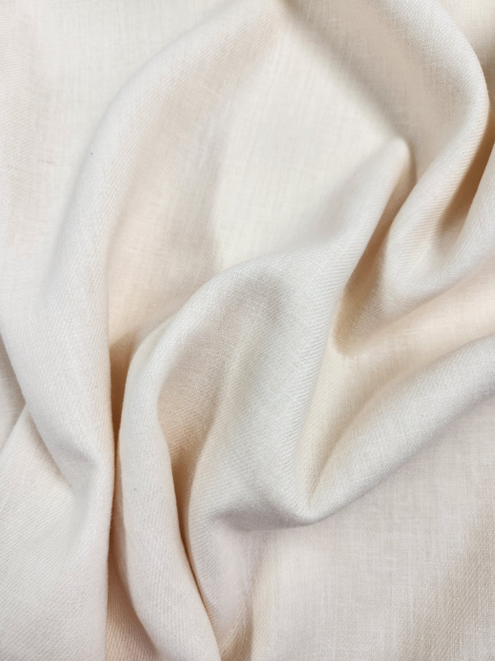 A close-up of soft, crumpled Pure Washed Linen in Eggnog from Super Cheap Fabrics shows its smooth texture and gentle folds, creating depth and softness.