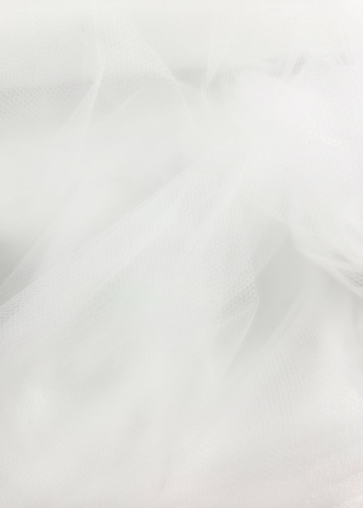 Close-up of Soft Tulle - White - 150cm by Super Cheap Fabrics, featuring sheer, airy layers with fine mesh and smooth folds—ideal for elegant bridal veils or dreamy costumes.