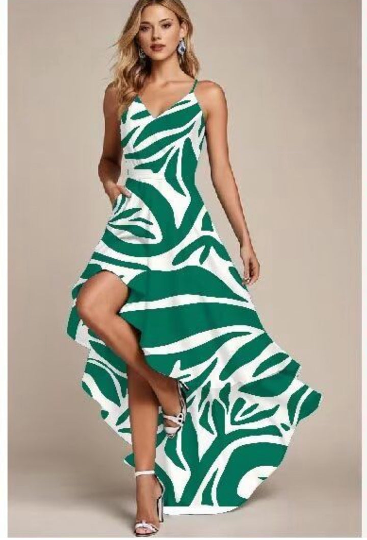 A woman stands in heels against a beige background, wearing a green and white zebra-print high-low dress made from Super Cheap Fabrics' Mercerised Rayon - Tropic Cutout (150cm), featuring thin straps and breathable fabric.
