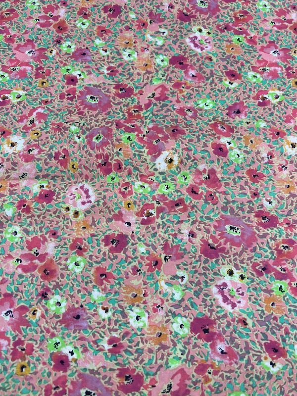 The Super Cheap Fabrics' Printed Cotton - Poppy Colours - 112cm features a vibrant floral pattern with pink, red, and white flowers on a green and beige background, evoking the lively essence of spring or summer.