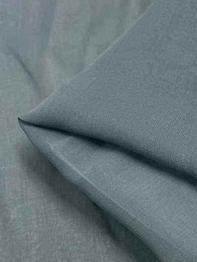 Close-up of folded Pure Silk Georgette - Mercury by Super Cheap Fabrics, highlighting its smooth texture and subtle sheen. The lightweight 135cm fabric is neatly laid out to emphasize its soft appearance and gentle draping, ideal for spring outfits.