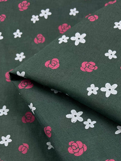 The Linen Voile - Roses by Super Cheap Fabrics, featuring a pattern of small pink roses and white flowers, is shown folded. The fabric measures 145cm.