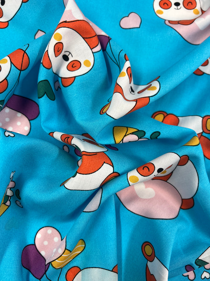 A close-up of Super Cheap Fabrics' "Printed Rayon - Cuddle - 145cm" showcases a playful print with cartoon pandas, colorful balloons, and hearts. This lightweight, slightly crumpled fabric is perfect for dresses due to its soft texture and vibrant design.