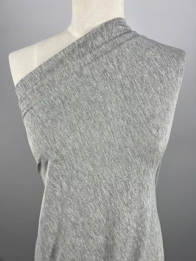 A gray, sleeveless top with a one-shoulder design displayed on a mannequin against a plain gray background. Made from medium weight fabric, Super Cheap Fabrics' Cotton Lycra - Grey marle - 150cm has a slight heathered texture.