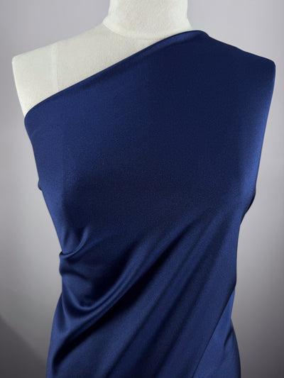 A mannequin wears Super Cheap Fabrics' Nylon Lycra - Midnight Sail (154cm), displaying its smooth texture, four-way stretch, and elegant drape in a one-shoulder style against a neutral background.