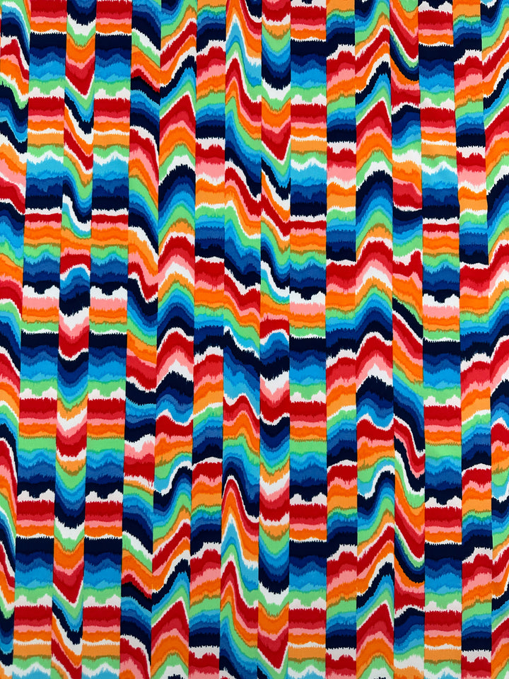 The Printed Nylon Lycra - Fuzz & Waves by Super Cheap Fabrics features a colorful abstract pattern of wavy stripes in red, orange, yellow, green, blue, and white on soft fabric. The varying stripe thickness offers a dynamic mosaic across this high-quality 152cm print.