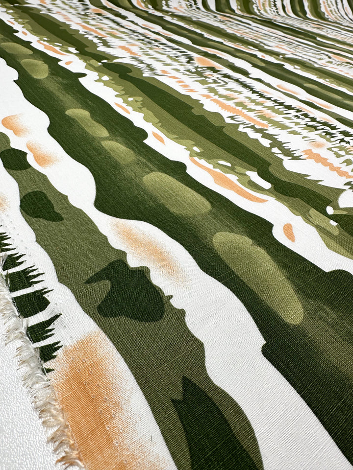 A close-up of Super Cheap Fabrics’ Bamboo Rayon - Torn Camo (150cm), featuring a lightweight weave, fringed edge, and green, beige, and white camouflage—ideal for beginner-friendly sewing projects.