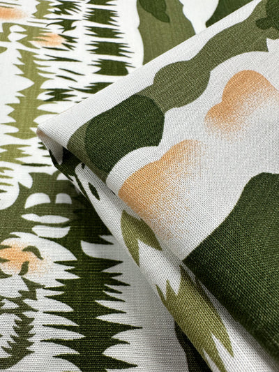 A close-up of Bamboo Rayon - Torn Camo by Super Cheap Fabrics (150cm), featuring lightweight fabric with green, beige, and white abstract camouflage. Beginner-friendly, it shows organic shapes and jagged, brush-like designs.