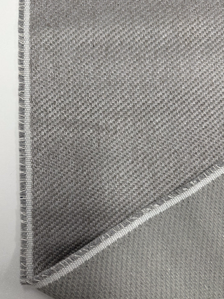 A close-up of two overlapping pieces of Twill Upholstery - Rex 370 - 150cm by Super Cheap Fabrics, in light gray deadstock with visible weaves and slightly frayed edges, shown on a white background.