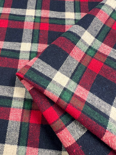 Close-up of folded Cherry Tattersal fabric from Super Cheap Fabrics, featuring a classic red, green, navy, and cream check pattern. This 150cm suiting fabric offers a soft texture and lightweight feel with the pattern flawlessly aligned across the folds.