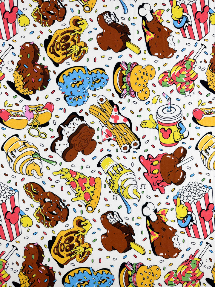 The "Printed Rayon - Treat - 140cm" by Super Cheap Fabrics showcases playful cartoon-style patterns of burgers, hot dogs, pizza, popcorn, ice cream cones, and drinks on a white background. The vibrant prints are scattered randomly on this versatile fabric.