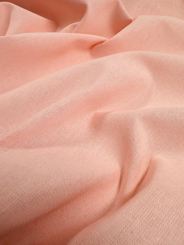 Super Cheap Fabrics' Ramie Linen in Seashell Pink drapes in smooth, flowing folds, crafted from natural fibers with a slight texture. Despite its delicate look, this 150cm fabric offers durability and warmth, providing a perfect mix of strength and comfort.