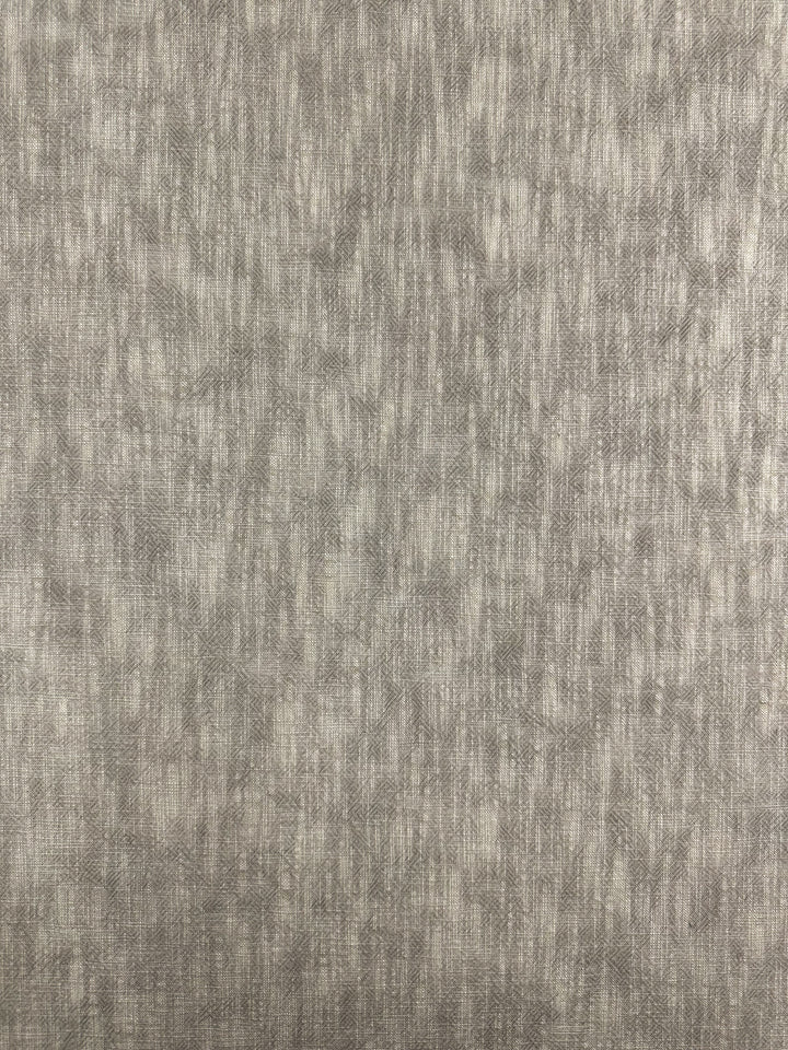 A close-up of the Basket Dyed Cotton in Taupe from Super Cheap Fabrics reveals a textured gray fabric with a subtle, uneven twill weave pattern. The surface appears soft and slightly reflective, creating a muted, natural look ideal for durable upholstery fabric at 140cm width.