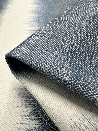 The Upholstery Jacquard - Pacific by Super Cheap Fabrics features a speckled woven pattern with a gradient from dark blue to light cream, offering intricate detail and elegance at an affordable price. Perfect for enhancing any space, this fabric measures 140cm wide.