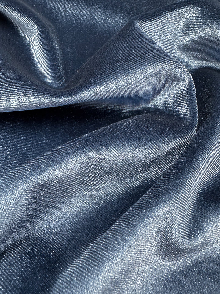 Close-up of a smooth, shimmering Stretch Velour - Naval Academy by Super Cheap Fabrics shows soft folds with a metallic sheen. The elegant, silky texture reflects light at various angles, exemplifying the medium weight's graceful drape. Width: 155cm.