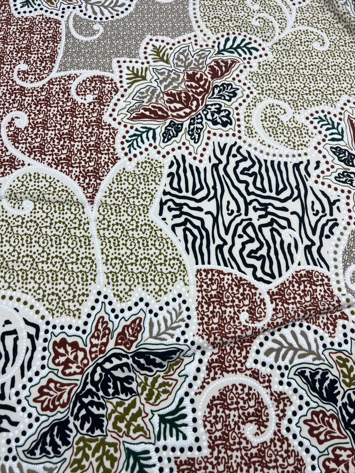 A close-up of Textured Lycra - Outline - 150cm by Super Cheap Fabrics, showcasing a medium-weight material adorned with an intricate pattern of leaves and abstract designs in shades of brown, green, red, and black against a white background. This Polyester/Spandex fabric features zebra-like stripes combined with densely packed dots, resulting in a complex and textured appearance.