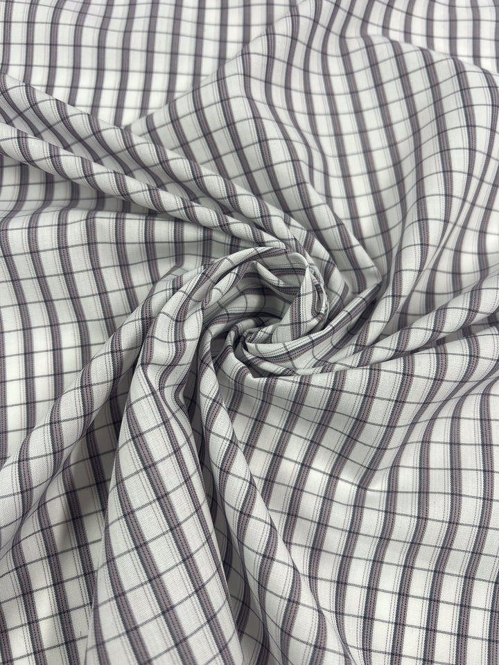 Close-up of Shirting - Dave - 147cm by Super Cheap Fabrics shows lightweight cotton with black, white, and gray checks, gathered into a spiral.