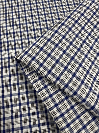 Close-up of Super Cheap Fabrics' "Shirting - Roy - 147cm," showcasing a blue and white plaid pattern. The classic checked design forms darker blue squares on a light polyester-cotton blend, perfect for children's wear.