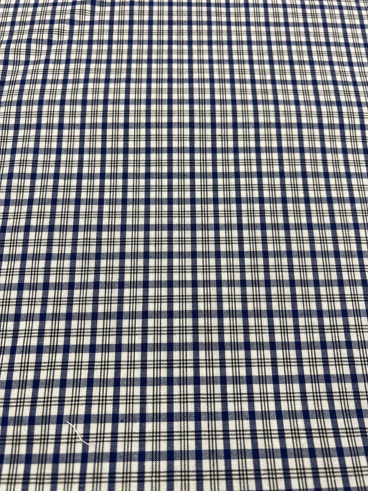 A close-up of the blue and white checkered "Shirting - Roy - 147cm" fabric from Super Cheap Fabrics, crafted from a polyester cotton blend. The lightweight design features a uniform grid pattern ideal for children's wear.