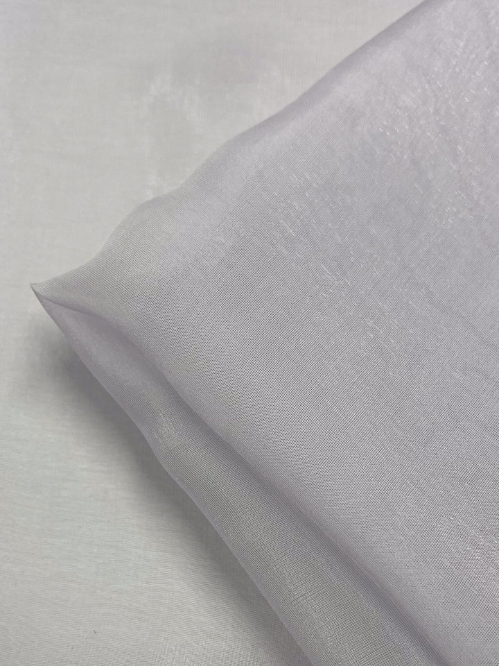 Close-up of a folded piece of Silk Mousseline in Orchid by Super Cheap Fabrics. This extra lightweight fabric, with a delicate weave and a smooth texture, appears slightly sheer, highlighting its soft sheen. Width: 140cm.