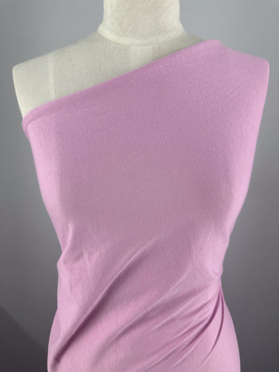 A mannequin draped in Super Cheap Fabrics' Cotton Jersey in Pastel Lavender, 160cm, styled with a one-shoulder design against a plain gray background.