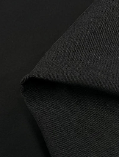 A close-up of Super Cheap Fabrics' Heavyweight Sateen - Black - 125cm shows its textured surface and medium heavy weight. Folded over, it forms a distinct edge with lighting highlighting the weave, contrasting to emphasize its smoothness and quality.