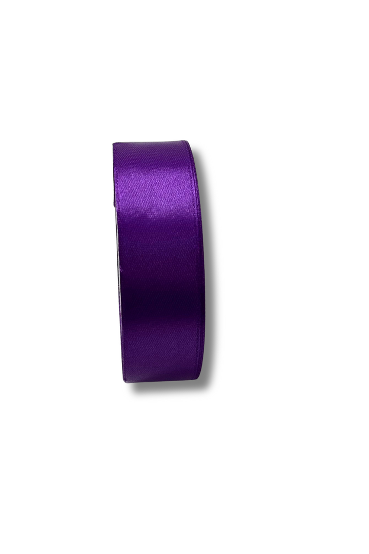 A roll of Super Cheap Fabrics Satin Ribbon, 25mm wide and in a shiny purple shade, stands upright on a white background.