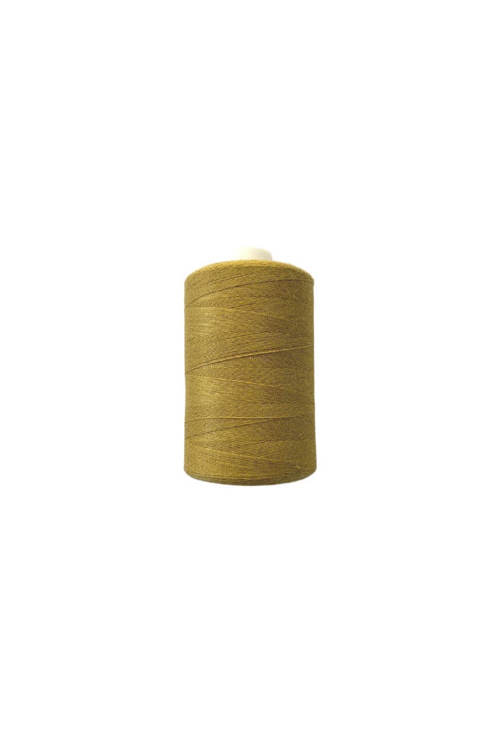 A large spool of Thread - Gold from Super Cheap Fabrics is placed against a plain white background. The spun polyester thread, neatly wound around the spool, stretches up to 1000 meters and is ready for use in sewing or textile projects.