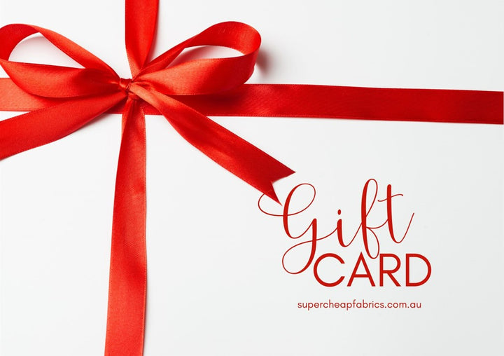 A white Super Cheap Fabrics Gift Vouchers with a red ribbon bow on the top left corner. The words "Gift Vouchers" are written in red cursive on the right side, below which is "supercheapfabrics.com.au" in smaller red text—an ideal treat for any sewing enthusiast to redeem online.