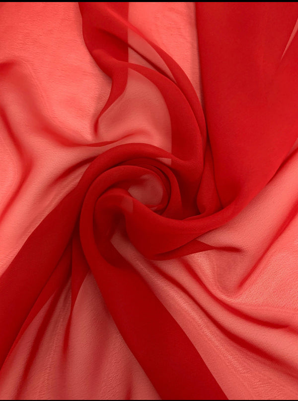 A close-up image of soft red Hi-Multi Chiffon - Red - 150cm from Super Cheap Fabrics. The light and dark red hues create a swirling pattern, displaying the delicate, sheer fabric's translucent texture. Gently gathered and laid out, the lightweight fabric creates flowing folds and a sense of movement, perfect for floaty tops.